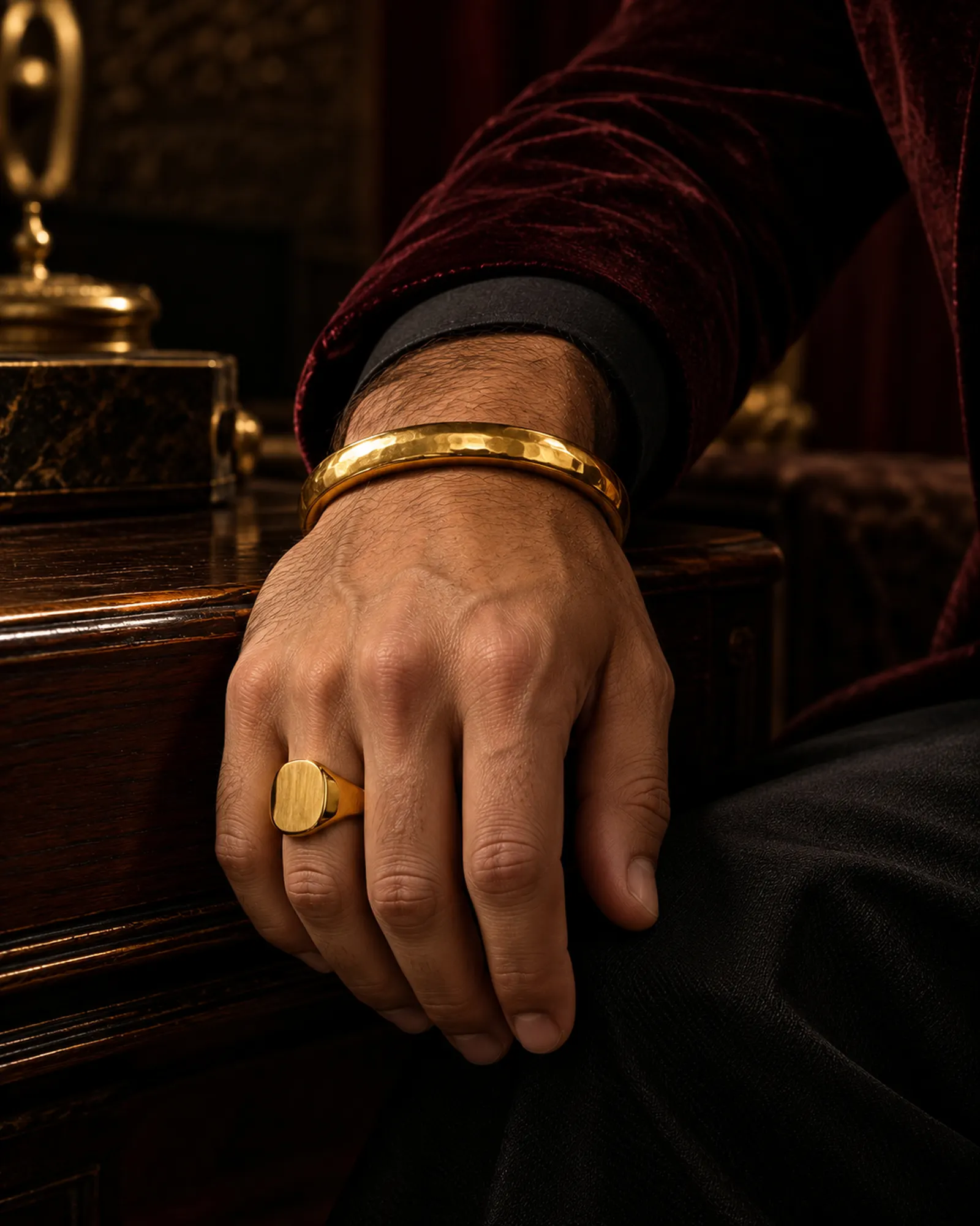 A gold kada and signet ring on a man's hand
